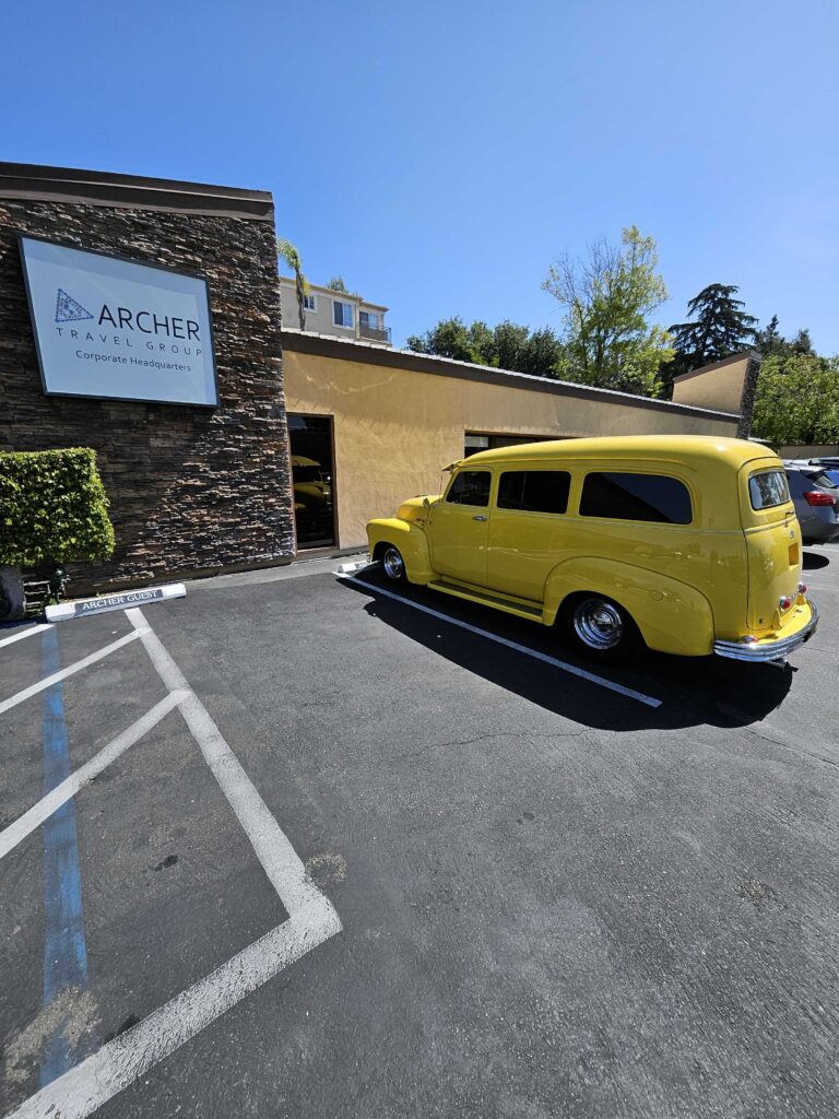 1952 yellow Chevy Suburban parked outside Archer Travel Group headquarters, representing the Archer Rivas Foundation.